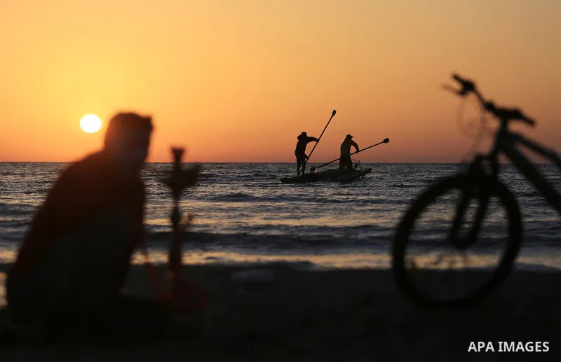 Palestinains ride a boat during sunset at the beach of the Mediterranean sea on the coast of Gaza city on April 17, 2016. Photo by Yasser Qudih