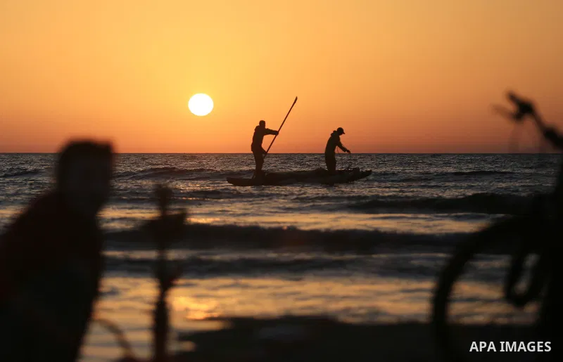Palestinains ride a boat during sunset at the beach of the Mediterranean sea on the coast of Gaza city on April 17, 2016. Photo by Yasser Qudih