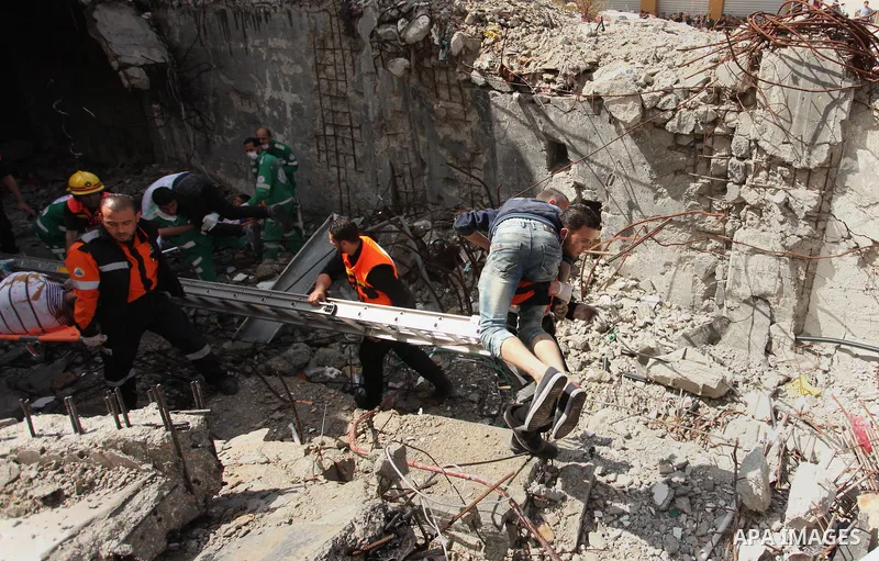 Palestinian emergency personnel take part in a drill in a building which was destroyed during the 50-day war between Israel and Hamas militants in the summer of 2014, in Gaza City, on April 19, 2016. Photo by Ashraf Amra