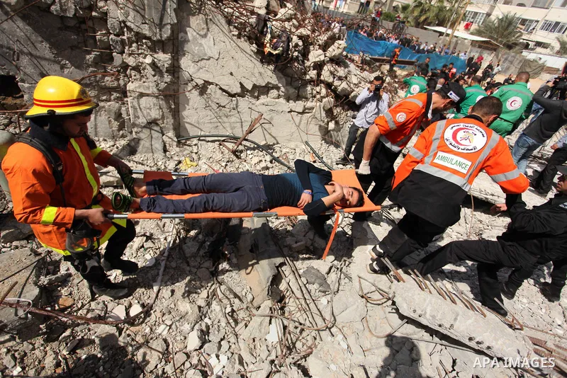 Palestinian emergency personnel take part in a drill in a building which was destroyed during the 50-day war between Israel and Hamas militants in the summer of 2014, in Gaza City, on April 19, 2016. Photo by Ashraf Amra