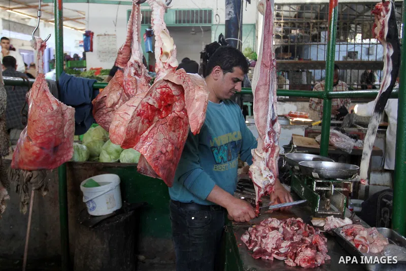 A Palestinian man sells meat at his shop in a market in Rafah in the southern Gaza Strip, April 19, 2016. Photo by Abed Rahim Khatib