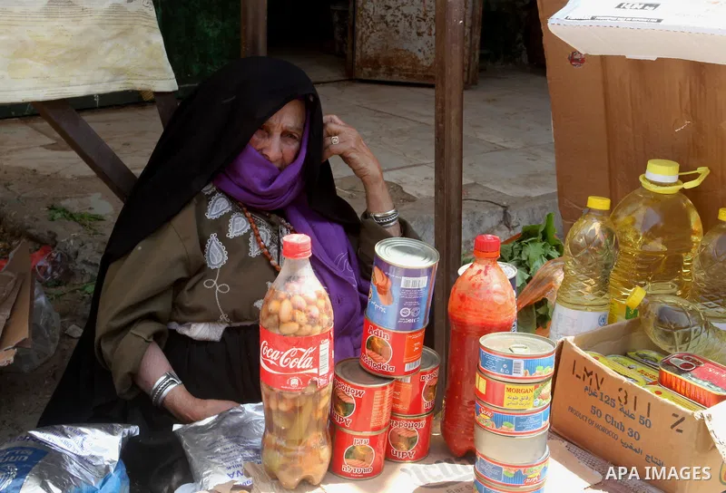 A Palestinian woman sells goods at a market in Rafah in the southern Gaza Strip, April 19, 2016. Photo by Abed Rahim Khatib