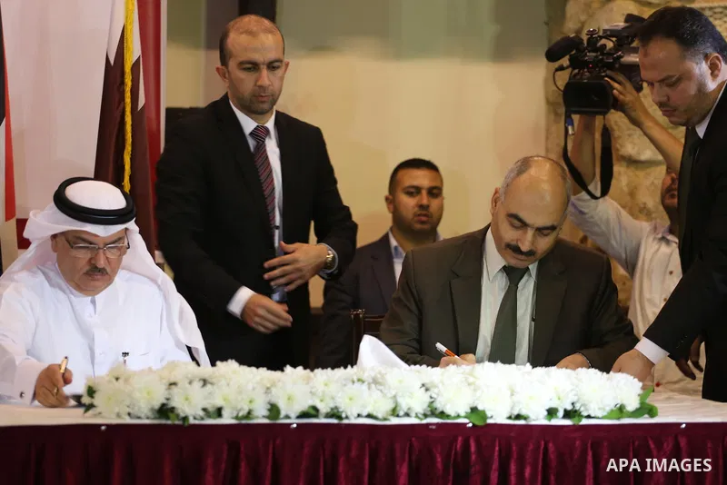 Palestinian housing minister Mufeed al-Hasayna, and Qatari ambassador Mohammed al-Emadi take part in a signing ceremony of agreement of new projects in Gaza city, on April 19, 2016. Photo by Mohammed Asad