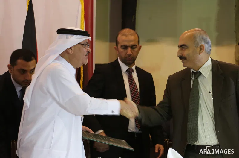 Palestinian housing minister Mufeed al-Hasayna, and Qatari ambassador Mohammed al-Emadi take part in a signing ceremony of agreement of new projects in Gaza city, on April 19, 2016. Photo by Mohammed Asad