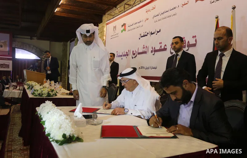 Palestinian housing minister Mufeed al-Hasayna, and Qatari ambassador Mohammed al-Emadi take part in a signing ceremony of agreement of new projects in Gaza city, on April 19, 2016. Photo by Mohammed Asad