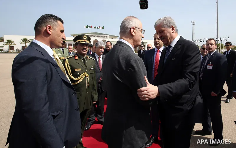Algerian Prime Minister Abdelmalek Sellal shake hands with Palestinian Prime Minister Rami Hamdallah before leaving Algerian Houari Boumediene International Airport in the capital Algiers on April 19, 2016. Photo by Prim...