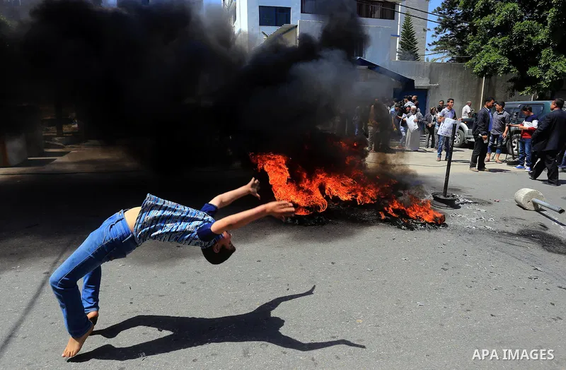 Palestinian owners of houses which were destroyed during the recent Israeli war, burn tires during a protest, in front of high commissioner for human rights headquarters, in Gaza City on April 20, 2016. Israeli occupatio...