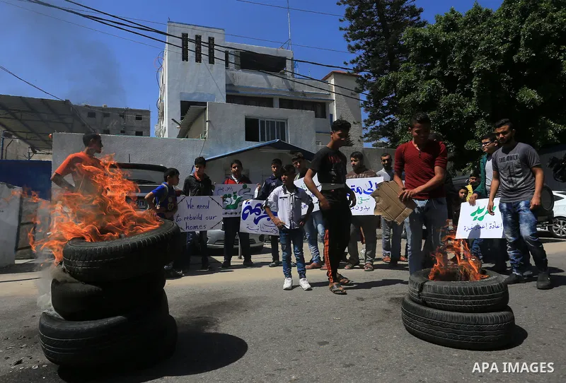 Palestinian owners of houses which were destroyed during the recent Israeli war, burn tires during a protest, in front of high commissioner for human rights headquarters, in Gaza City on April 20, 2016. Israeli occupatio...