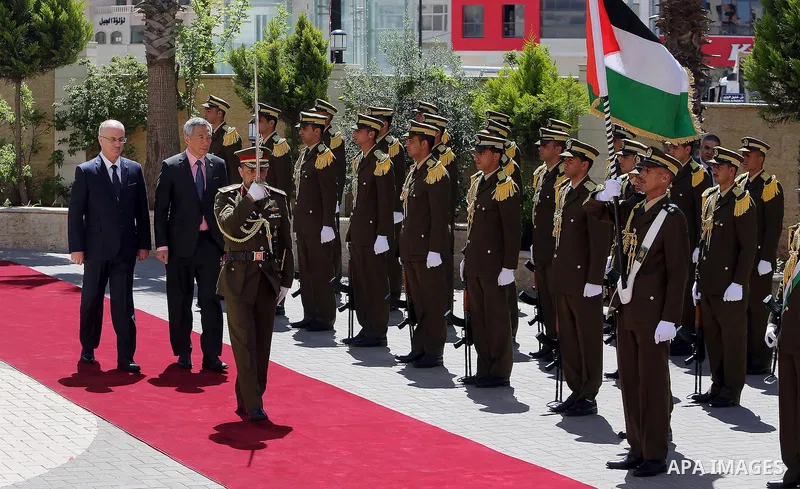 Palestinian Prime Minister Rami Hamdallah and Singapore's Prime Minister Lee Hsien Loong review the honour guard upon Lee's arrival in the West Bank city of Ramallah, April 20, 2016. Photo by Prime Minister Office
