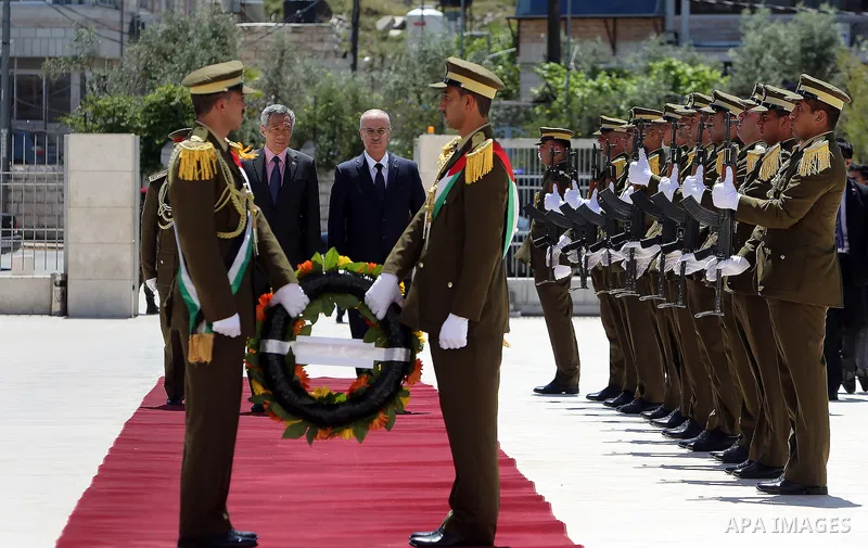 Palestinian Prime Minister Rami Hamdallah and Singapore's Prime Minister Lee Hsien Loong review the honour guard upon Lee's arrival in the West Bank city of Ramallah, April 20, 2016. Photo by Prime Minister Office