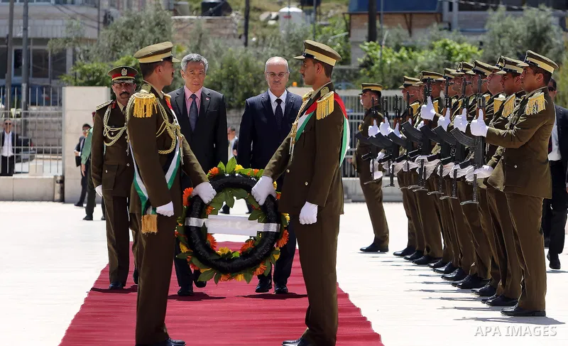 Palestinian Prime Minister Rami Hamdallah and Singapore's Prime Minister Lee Hsien Loong review the honour guard upon Lee's arrival in the West Bank city of Ramallah, April 20, 2016. Photo by Prime Minister Office