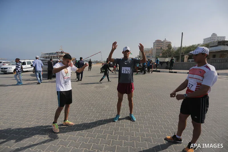 Palestinian youths take part in a marathon organized by Hamas and Fateh movement to mark Palestinian Prisoner Day, in Gaza city, on April 23, 2016. Photo by Mohammed Asad