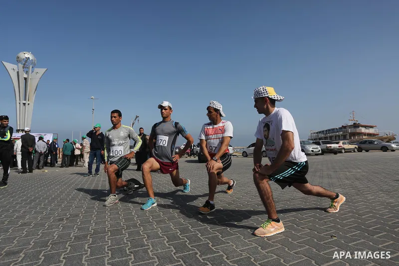 Palestinian youths take part in a marathon organized by Hamas and Fateh movement to mark Palestinian Prisoner Day, in Gaza city, on April 23, 2016. Photo by Mohammed Asad