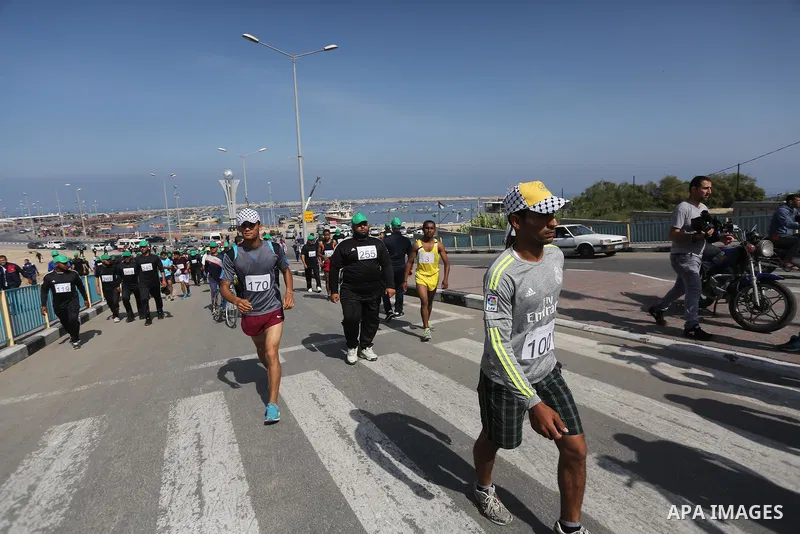 Palestinian youths take part in a marathon organized by Hamas and Fateh movement to mark Palestinian Prisoner Day, in Gaza city, on April 23, 2016. Photo by Mohammed Asad