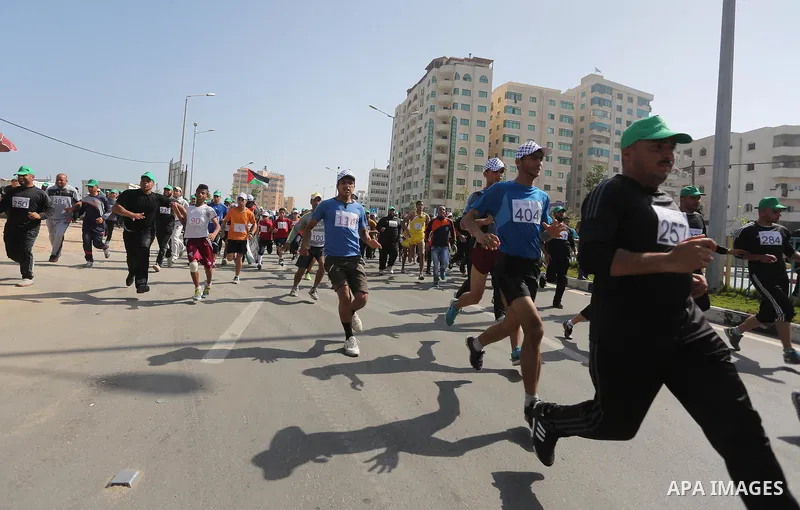 Palestinian youths take part in a marathon organized by Hamas and Fateh movement to mark Palestinian Prisoner Day, in Gaza city, on April 23, 2016. Photo by Mohammed Asad