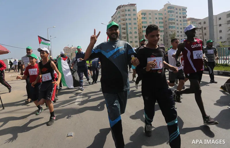 Palestinian youths take part in a marathon organized by Hamas and Fateh movement to mark Palestinian Prisoner Day, in Gaza city, on April 23, 2016. Photo by Mohammed Asad