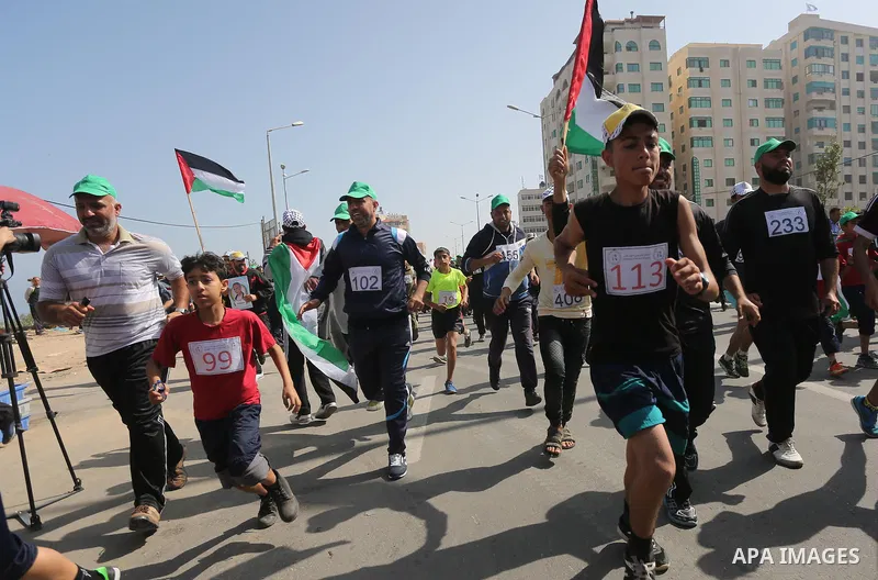 Palestinian youths take part in a marathon organized by Hamas and Fateh movement to mark Palestinian Prisoner Day, in Gaza city, on April 23, 2016. Photo by Mohammed Asad