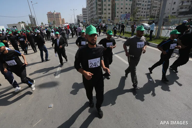 Palestinian youths take part in a marathon organized by Hamas and Fateh movement to mark Palestinian Prisoner Day, in Gaza city, on April 23, 2016. Photo by Mohammed Asad
