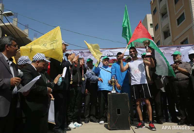 Palestinian youths take part in a marathon organized by Hamas and Fateh movement to mark Palestinian Prisoner Day, in Gaza city, on April 23, 2016. Photo by Mohammed Asad