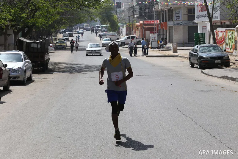 Palestinian youths take part in a marathon organized by Hamas and Fateh movement to mark Palestinian Prisoner Day, in Gaza city, on April 23, 2016. Photo by Mohammed Asad
