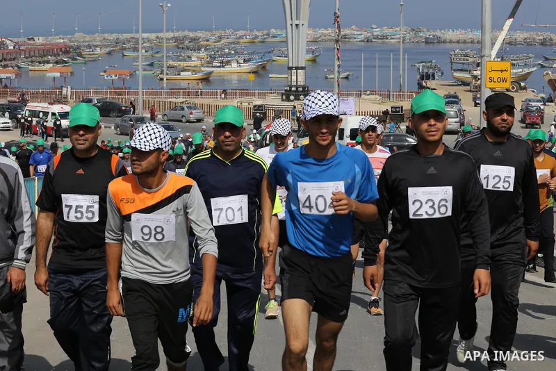 Palestinian youths take part in a marathon organized by Hamas and Fateh movement to mark Palestinian Prisoner Day, in Gaza city, on April 23, 2016. Photo by Mohammed Asad