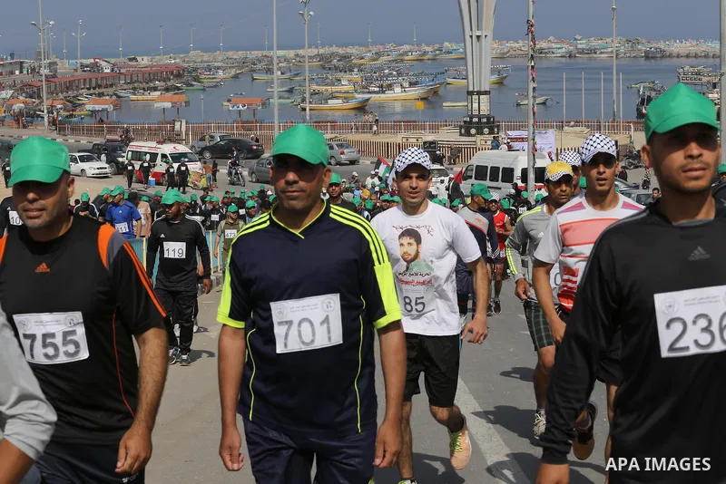 Palestinian youths take part in a marathon organized by Hamas and Fateh movement to mark Palestinian Prisoner Day, in Gaza city, on April 23, 2016. Photo by Mohammed Asad