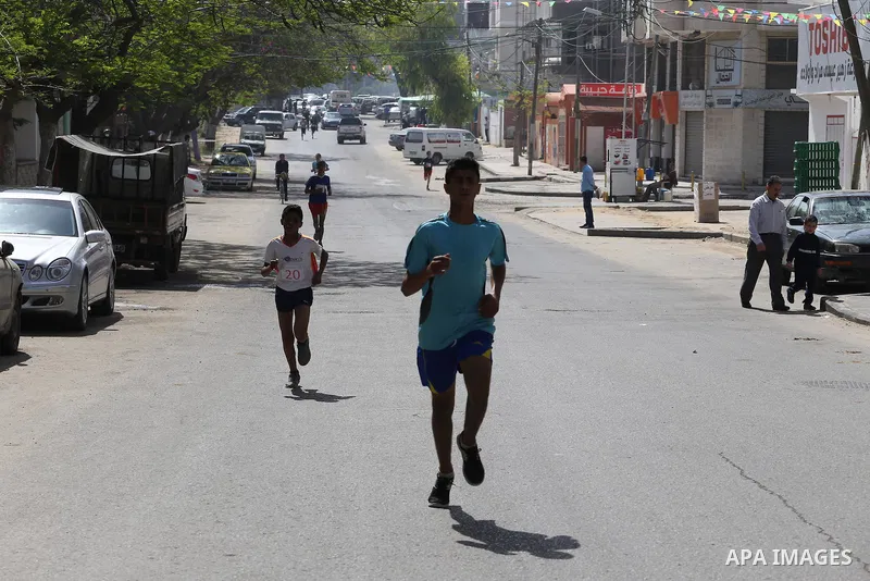 Palestinian youths take part in a marathon organized by Hamas and Fateh movement to mark Palestinian Prisoner Day, in Gaza city, on April 23, 2016. Photo by Mohammed Asad