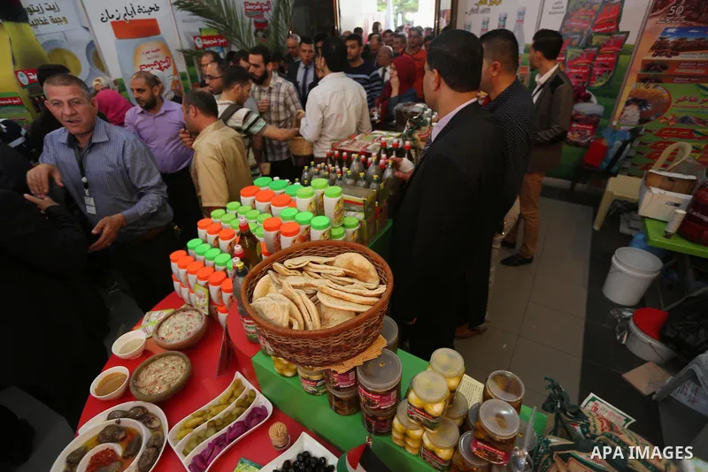 Palestinians attend exhibition for national products at Islamic University, in Gaza city, on April 24, 2016. Photo by Mohammed Asad
