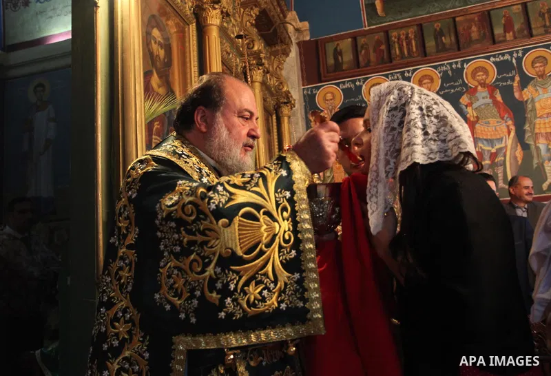 Reverend Archbishop of Tiberias, Alexios, gives the eucharist during the Greek Orthodox Christian Palm Sunday mass at St.Porphyrios Church in Gaza City, on April 24, 2016. Palm Sunday marks the triumphant return of Jesus...