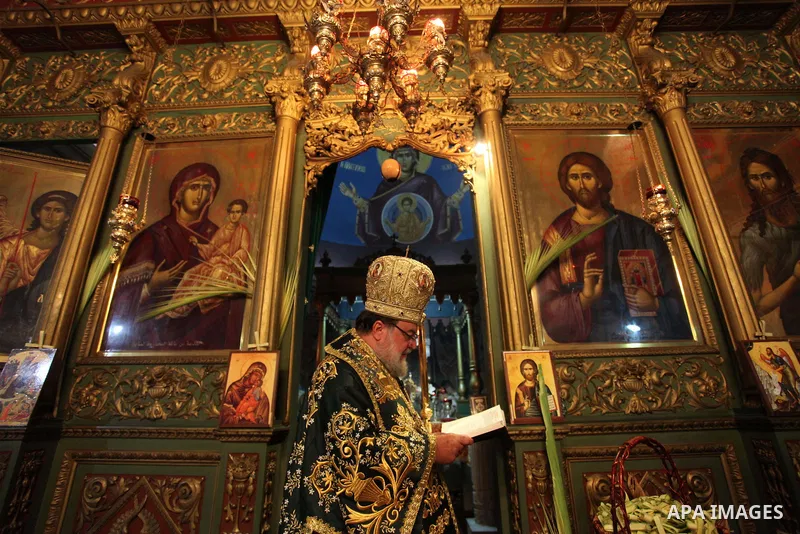 Reverend Archbishop of Tiberias, Alexios, gives the eucharist during the Greek Orthodox Christian Palm Sunday mass at St.Porphyrios Church in Gaza City, on April 24, 2016. Palm Sunday marks the triumphant return of Jesus...