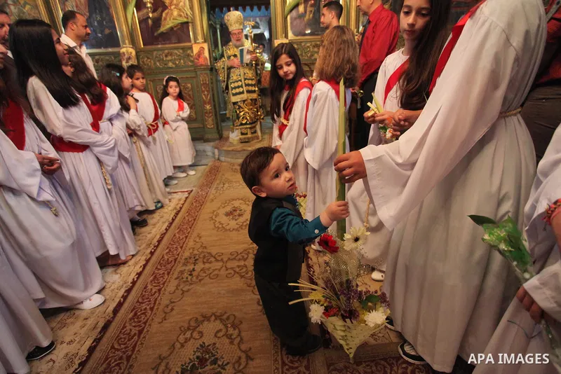 Reverend Archbishop of Tiberias, Alexios, gives the eucharist during the Greek Orthodox Christian Palm Sunday mass at St.Porphyrios Church in Gaza City, on April 24, 2016. Palm Sunday marks the triumphant return of Jesus...