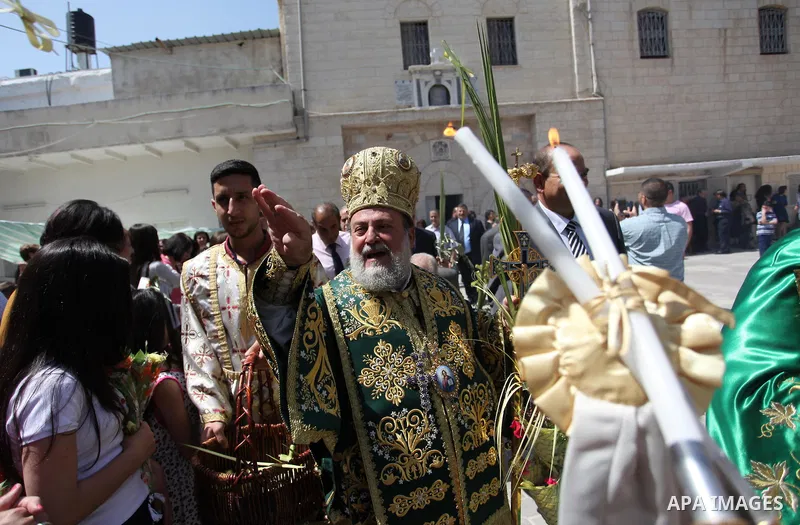 Reverend Archbishop of Tiberias, Alexios, gives the eucharist during the Greek Orthodox Christian Palm Sunday mass at St.Porphyrios Church in Gaza City, on April 24, 2016. Palm Sunday marks the triumphant return of Jesus...