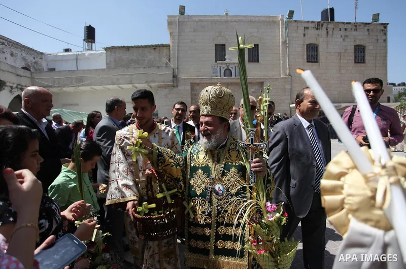 Reverend Archbishop of Tiberias, Alexios, gives the eucharist during the Greek Orthodox Christian Palm Sunday mass at St.Porphyrios Church in Gaza City, on April 24, 2016. Palm Sunday marks the triumphant return of Jesus...