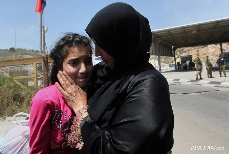 Released Palestinian prisoner Deema Al-Wawi, 12, who was detained by Israeli authorities for around two and half months, hugs her mother following her release near the West Bank city of Tulkarm April 24, 2016. Photo by N...