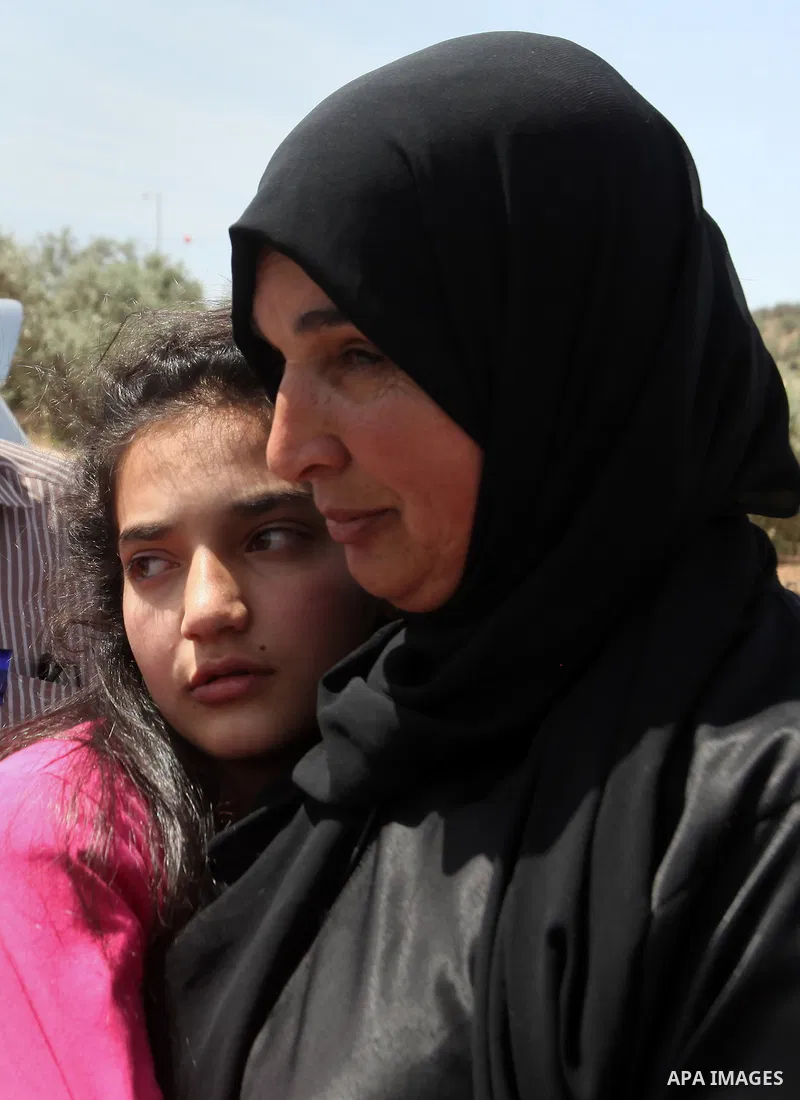 Released Palestinian prisoner Deema Al-Wawi, 12, who was detained by Israeli authorities for around two and half months, hugs her mother following her release near the West Bank city of Tulkarm April 24, 2016. Photo by N...