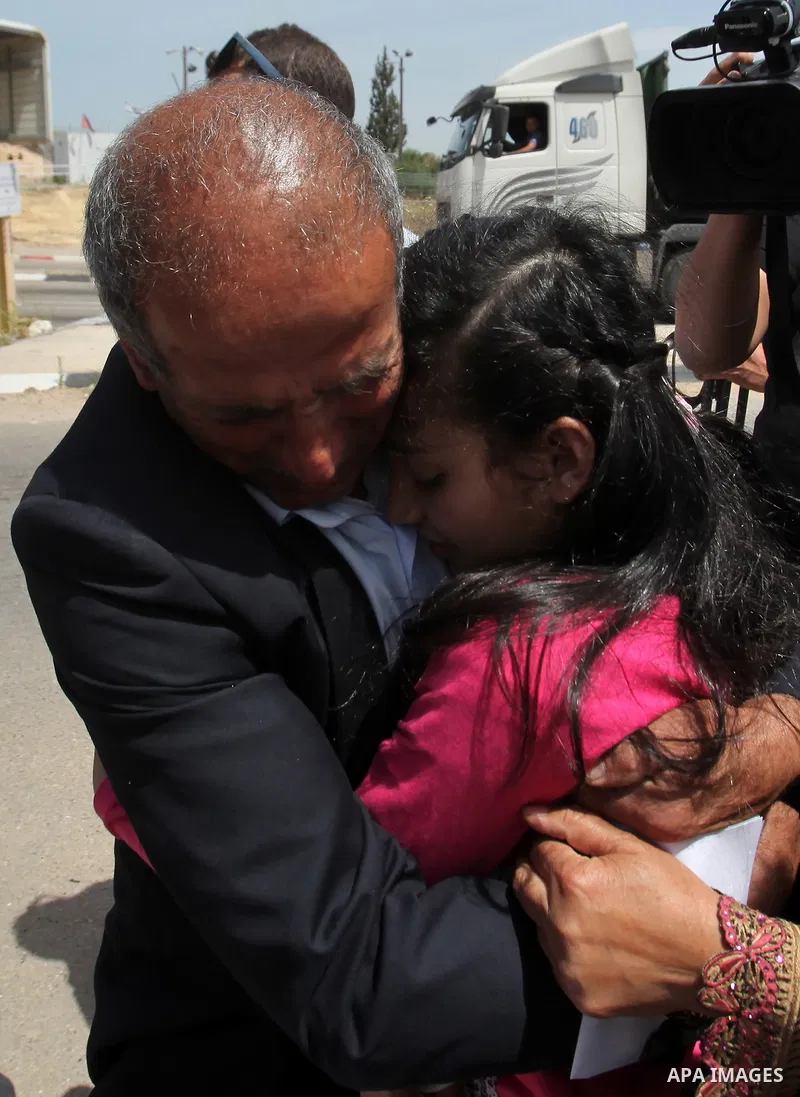 Released Palestinian prisoner Deema Al-Wawi, 12, who was detained by Israeli authorities for around two and half months, hugs her father following her release near the West Bank city of Tulkarm April 24, 2016. Photo by N...