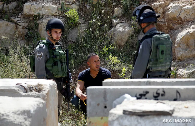 Israeli border police detain a Palestinian man in the West Bank city of Hebron April 24, 2016. Photo by Wisam Hashlamoun
