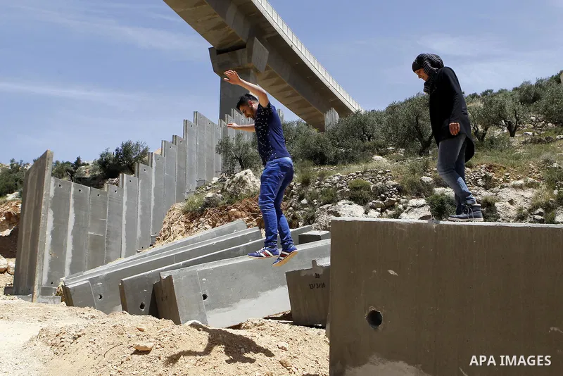 Palestinians hold a mass during a protest at the construction site of a section of the Israeli barrier in the West Bank city of Beit Jala, near Bethlehem April 24, 2016. Photo by Wisam Hashlamoun