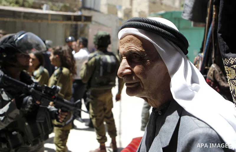 Israeli troops stand guard as Israeli settlers have a tour during the Jewish holiday of Passover in the West Bank city of Hebron, on April 25, 2016. Photo by Wisam Hashlamoun