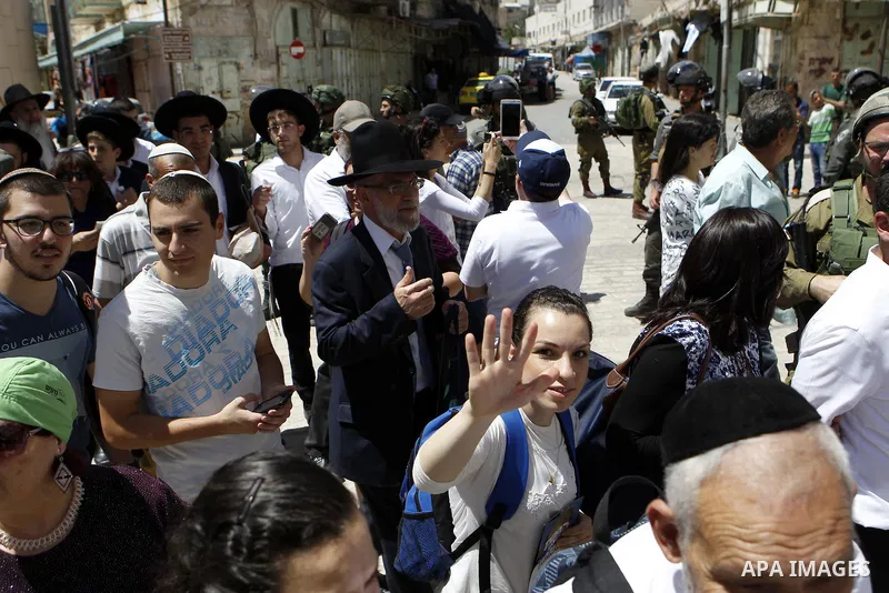 Israeli troops stand guard as Israeli settlers have a tour during the Jewish holiday of Passover in the West Bank city of Hebron, on April 25, 2016. Photo by Wisam Hashlamoun