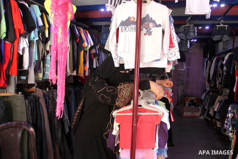 Palestinians looks at second hand clothes at a market in Rafah in the southern Gaza strip, on April 26, 2016. Due to the current economic situation in Gaza Strip, many of the Palestinians resort to meet their needs of us...