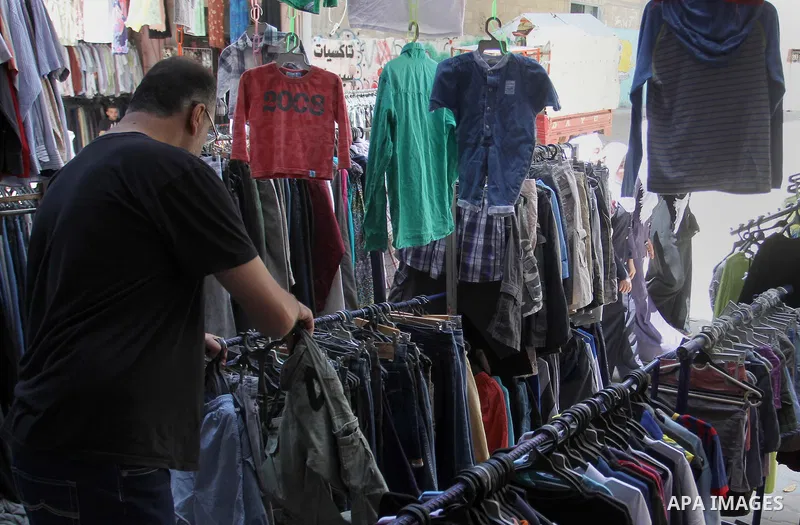 Palestinians looks at second hand clothes at a market in Rafah in the southern Gaza strip, on April 26, 2016. Due to the current economic situation in Gaza Strip, many of the Palestinians resort to meet their needs of us...