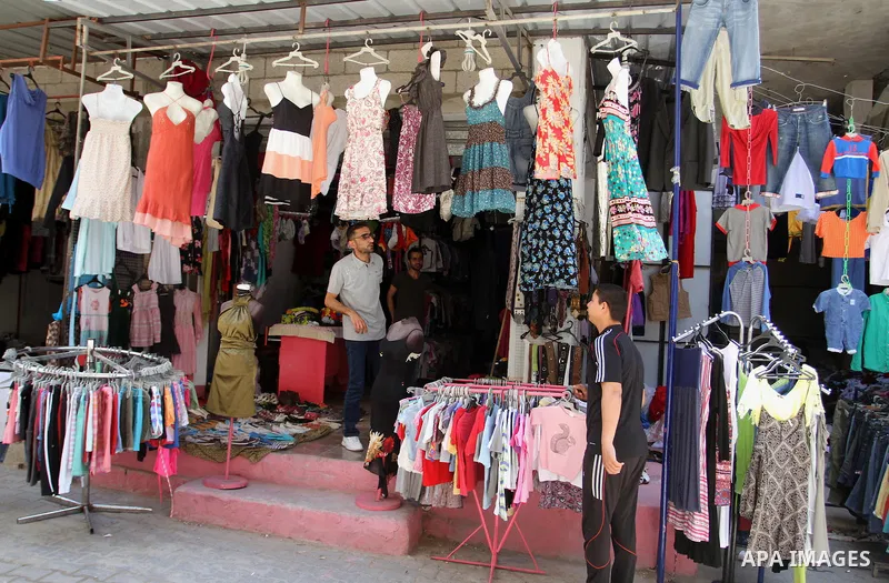 Palestinians looks at second hand clothes at a market in Rafah in the southern Gaza strip, on April 26, 2016. Due to the current economic situation in Gaza Strip, many of the Palestinians resort to meet their needs of us...