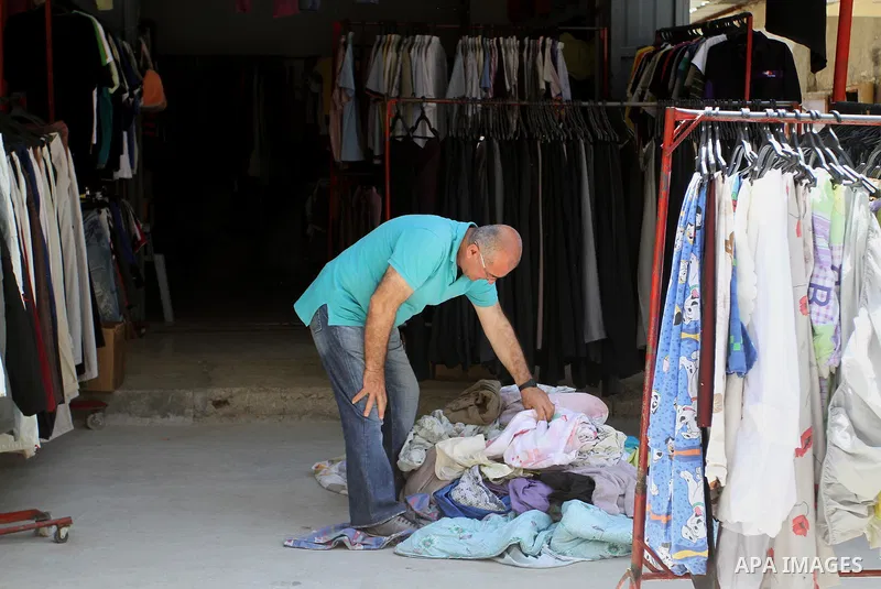 Palestinians looks at second hand clothes at a market in Rafah in the southern Gaza strip, on April 26, 2016. Due to the current economic situation in Gaza Strip, many of the Palestinians resort to meet their needs of us...