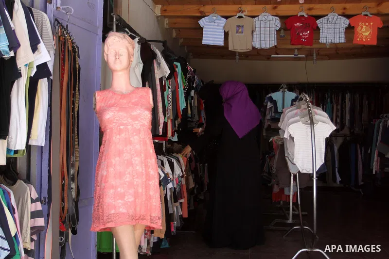 Palestinians looks at second hand clothes at a market in Rafah in the southern Gaza strip, on April 26, 2016. Due to the current economic situation in Gaza Strip, many of the Palestinians resort to meet their needs of us...