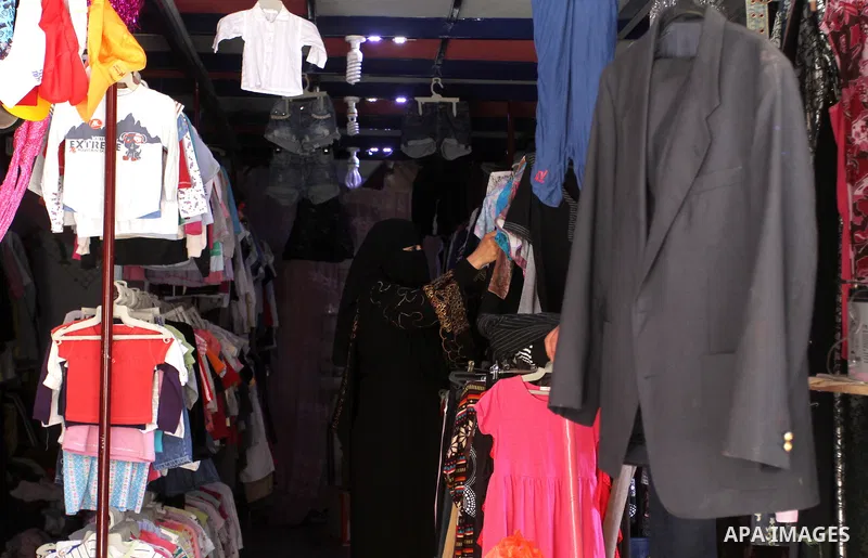 Palestinians looks at second hand clothes at a market in Rafah in the southern Gaza strip, on April 26, 2016. Due to the current economic situation in Gaza Strip, many of the Palestinians resort to meet their needs of us...