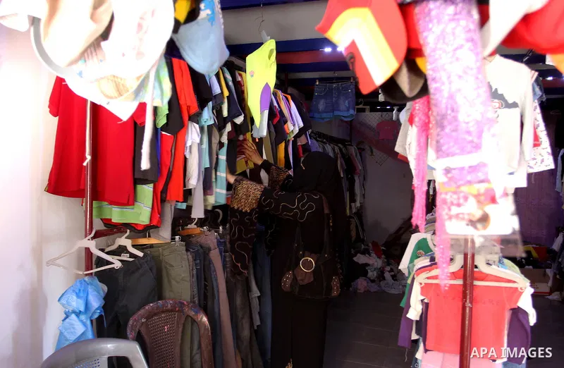 Palestinians looks at second hand clothes at a market in Rafah in the southern Gaza strip, on April 26, 2016. Due to the current economic situation in Gaza Strip, many of the Palestinians resort to meet their needs of us...
