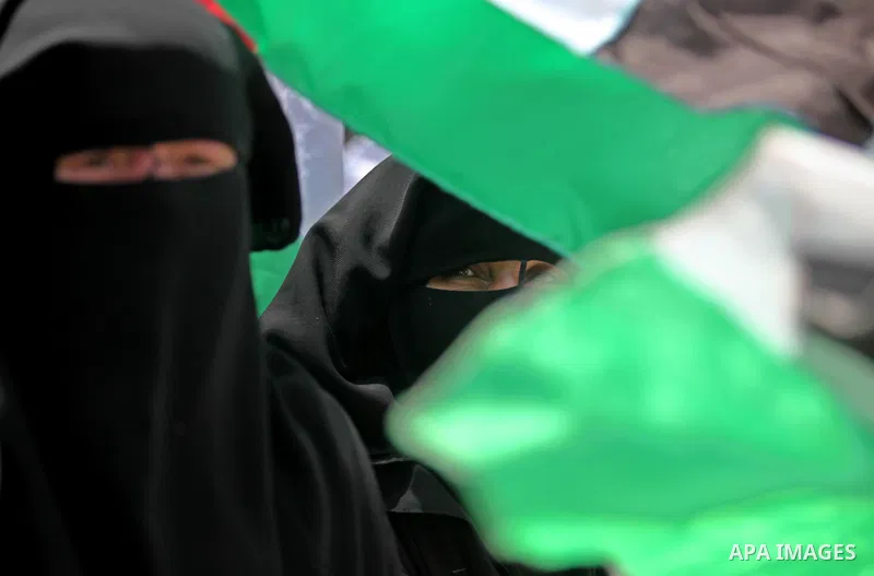 Palestinian women hold national flags during a demonstration to calling for an end in the political division and the national reconciliation in Gaza city, on April 26, 2016. Photo by Ashraf Amra