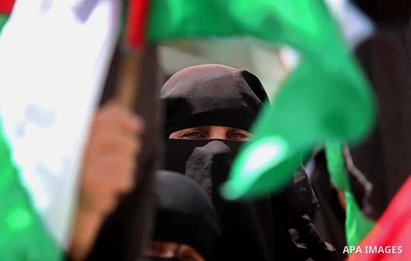 Palestinian women hold national flags during a demonstration to calling for an end in the political division and the national reconciliation in Gaza city, on April 26, 2016. Photo by Ashraf Amra