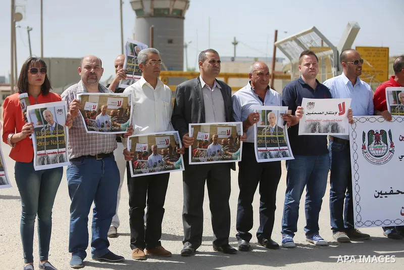 Palestinian journalists hold banners during a protest calling for the release of Palestinian journalist Omar Nazal, who is held by Israel, near Israel's Ofer Prison near the West Bank city of Ramallah April 26, 2016. Pho...